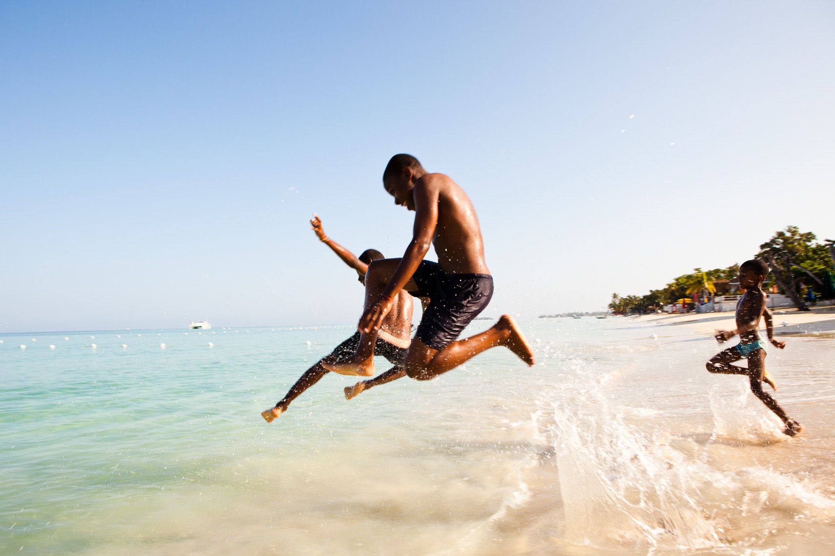 Jamaican kids jumping in ocean.